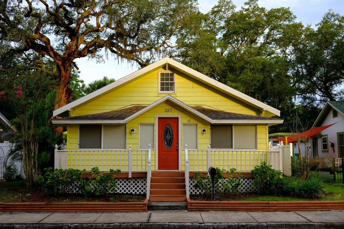 A Florida home with a tile roof and palm trees in the front yard